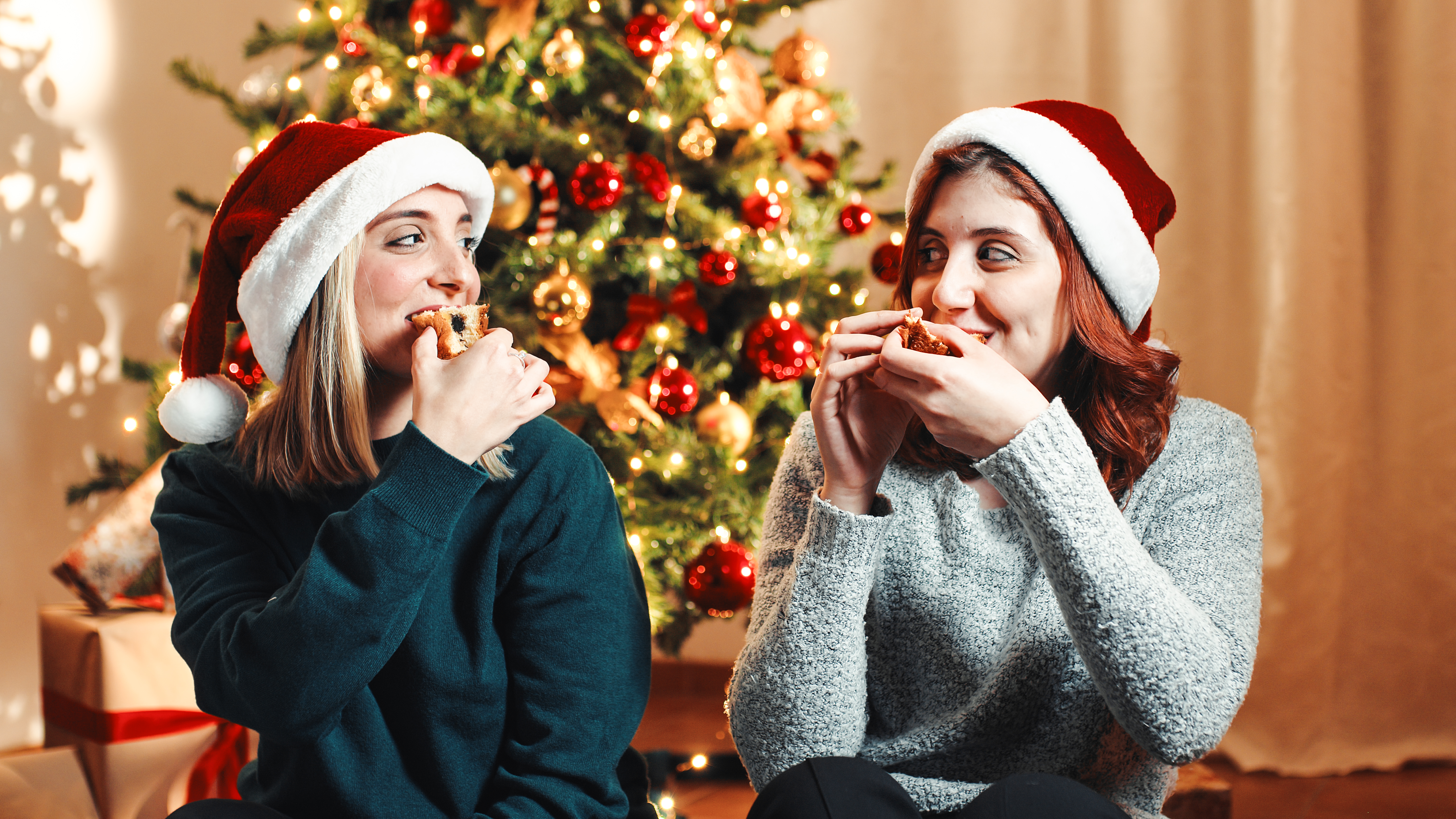 Two girls couple eat sweet in Christmas